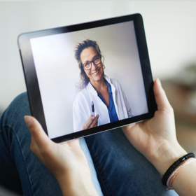 imagem de tablet onde se vê a imagem de uma médica